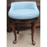 A dressing table stool with a pad upholstered seat