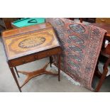 An early 20th century inlaid bureau together with a pink ground Turkoman rug