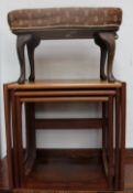 A teak nest of three tables together with an upholstered foot stool