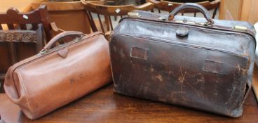 A dark brown leather doctors type leather bag together with another smaller example