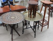 A brass topped table with folding base, together with another brass topped table,