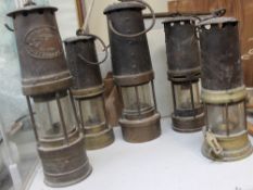 A Thomas and Williams miner's lamp together with four other miner's lamps