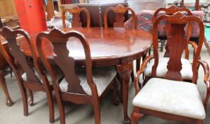 A reproduction walnut extending dining table with two leaves and six chairs including two carvers