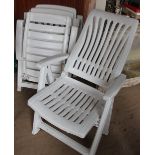 A set of three plastic folding garden chairs