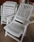 A set of three plastic folding garden chairs