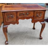 An 18th century style mahogany desk with a crossbanded top above three drawers on leaf carved