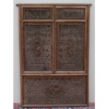 A Chinese carved screen, in the form of window shutters carved with figures, dogs of foo,