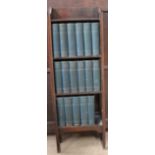 A small oak bookcase with seventeen volumes of the Charles Dickens Library