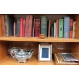 A silver photograph frame together with electroplated wares, books,