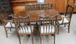 A 20th century oak dining suite comprising an extending dining table,