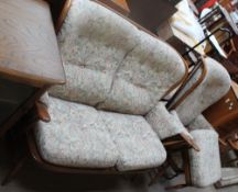 An Ercol two-seater settee with matching armchair and foot stool