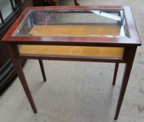A mahogany bijouterie table with a glazed top and sides on square tapering legs