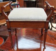 An Edwardian mahogany piano stool with turned handles and a pad seat on square tapering legs