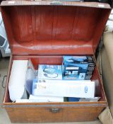 A tin trunk containing new and used items including a back massage cushion, Walkman,
