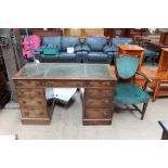 A 20th century mahogany pedestal desk together with elbow chair with leaf carved arm terminals