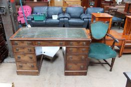 A 20th century mahogany pedestal desk together with elbow chair with leaf carved arm terminals