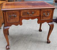 An 18th century style mahogany desk with a crossbanded top above three drawers on leaf carved