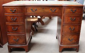 A 20th century burr walnut pedestal desk with a shaped leather inset top
