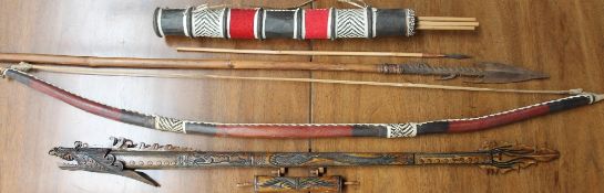 An Indonesian blow pipe with darts together with an African bow and arrows and a spear