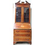 An Edwardian mahogany bureau bookcase with a moulded cornice above a pair of glazed doors with