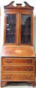 An Edwardian mahogany bureau bookcase with a moulded cornice above a pair of glazed doors with