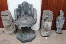 A reconstituted stone Easter Island type head together with two other statues and a garden seat