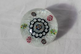 A 20th century glass paperweight, with floral canes and a swirling white decoration,