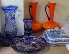 A pair of orange and black glass jugs together with blue flash glass vases and a blue and white