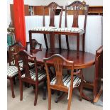 A reproduction mahogany extending dining table and six chairs
