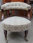 A late Victorian button back upholstered nursing chair with turned legs and casters