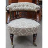 A late Victorian button back upholstered nursing chair with turned legs and casters