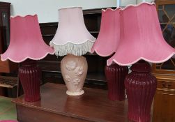 A pottery table lamp moulded with flowers together with a set of three pottery table lamps