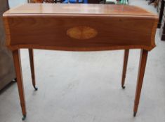 A Regency style mahogany Pembroke table with satinwood roundels and cross banding on square