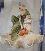 A Royal Dux figure of a lady in a green dress with a jug above a shell,