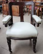 A Victorian mahogany elbow chair with pad upholstered arms and seat on turned front legs