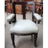 A Victorian mahogany elbow chair with pad upholstered arms and seat on turned front legs