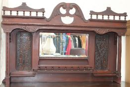 An overmantle mirror with a spindle cornice,