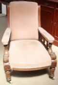 A late Victorian oak library chair with an upholstered back,