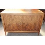 A 20th century teak sideboard with a rectangular top above a pair of cupboard doors with crossover