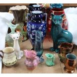 A Poole pottery cat together with a copper lustre jug, a purple lustre hunting jug,