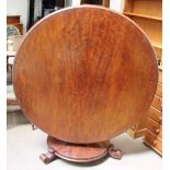 A Victorian mahogany supper table with a circular top above a tapering lotus leaf carved column,