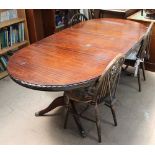 A reproduction mahogany extending dining table together with a set of four wheel back chairs