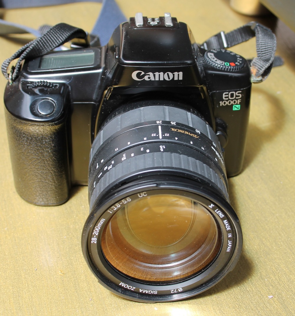 A Canon EOS 1000 camera together with other cameras and lenses