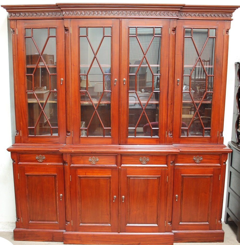 A modern wall unit the top with a moulded cornice above four glazed doors,