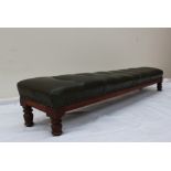 A Victorian kneeling stool with a button upholstered cushion on four ring turned legs,