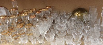 A large quantity of crystal and gilt decorated drinking glasses, decanter, rose bowl,