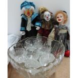 Three clown dolls together with a glass punch bowl and glasses
