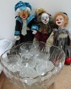 Three clown dolls together with a glass punch bowl and glasses