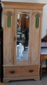 A Satin walnut wardrobe with a mirrored door and base drawer on bracket feet,