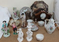 An 18th century English porcelain figure of a young boy playing a wind instrument with a dog at his